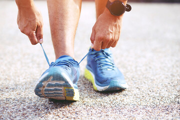 Running shoes. close up female athlete tying laces for jogging on road. Runner ties getting ready for training. Sport lifestyle. copy space banner.