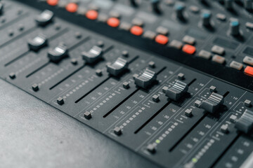 A recording studio control panel mixer with an equalizer faders buttons for broadcasting a recording of a song