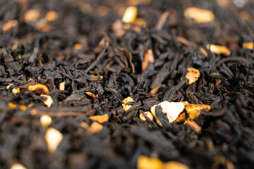 Black tea with orange peel and cinnamon close-up top view
