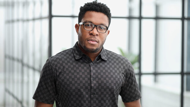Handsome businessman frowning at camera in his office
