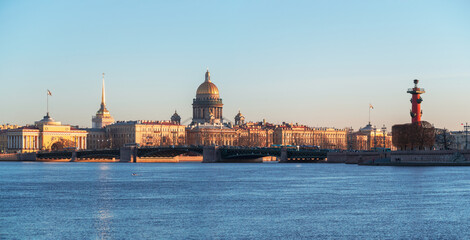 Fototapeta na wymiar Panorama of spring St. Petersburg with a view of St. Isaac's Cathedral. View from the Neva River. Sunset view of the Palace Bridge, city life, postcard views of the evening city.