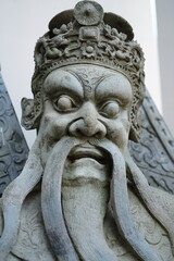 Sandstone sculptures dressed as ancient Chinese warriors in various poses at Wat Pho, Bangkok, Thailand.