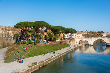 Rom, Italien, Apr. 2023 Menschen genießen die Ruhe auf der Tiberinsel an einem warmen sonnigen Frühlingstag - 590525173