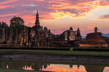 Obraz premium Ancient temples in Sukhothai Historical Park, Thailand, orange sunset