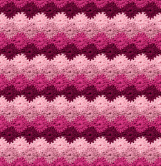 Seamless knitted texture in the form of flowers. The pattern is crocheted from multi-colored...