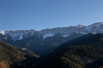 Sunset in some snowy mountains surrounded by pine forests