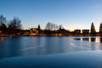Frozen lake at sunset next to some houses