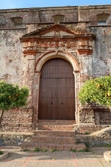 Fototapeta na wymiar Castano del Robledo, Huelva, Spain, March 30, 2023: Vertical view. Side door of the unfinished Church (18th century) in Castano del Robledo, Huelva. Spain