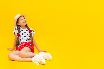 A beautiful little girl in polka dot shorts and a straw hat is pointing at your advertisement....