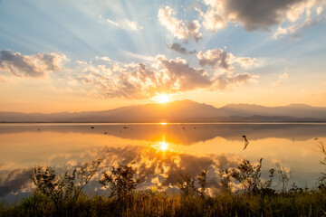 Fototapeta na wymiar Sunset over lake Phayao with reflection and bright colourful sky. 