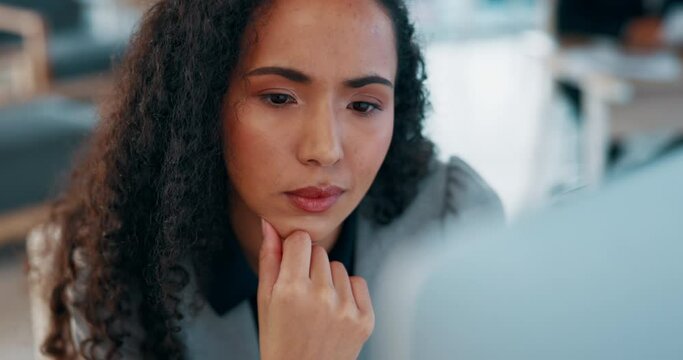 Serious, thinking and business woman on computer for project research, data analytics or online review in office. Biracial person working on desktop in focus, planning and editing proposal or report