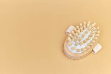 Wooden brush for anti-cellulite dry body massage, Natural wooden brush for body massage. Eco-friendly lifestyle concept and zero waste. Body care at home. Beige background, copy space