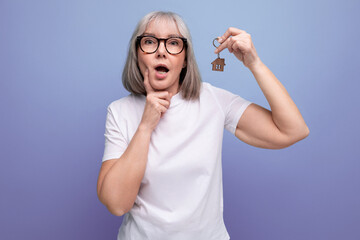turnkey property. mature woman pensioner holding apartment keychain