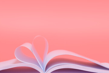 Book sheets in shape of heart isolated on pink background