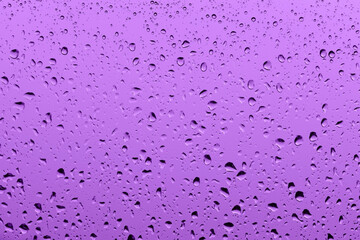 Macro photography of purple rain drops on the window glass