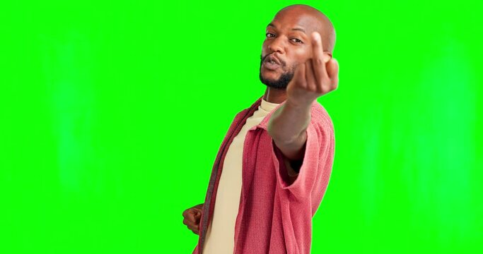 Portrait, rude and hand gesture with a black man on a green screen background saying fuck you. Angry, insult and middle finger with a young male on chromakey mockup feeling bad, unhappy or upset