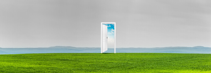 Geöffnete Tür ind einer Grünen Wiese vor einem Hügeligen Bergpanorama