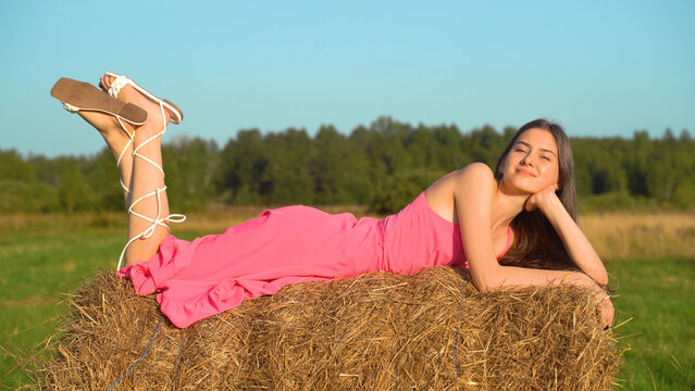 happy girl is lying on a haystack