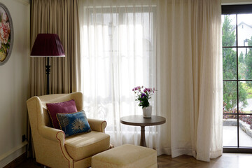 Sofa resting space by the window in a French style room with terrace                             