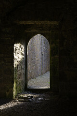 light falling through a arched door in a ruined abbey in ireland - obrazy, fototapety, plakaty