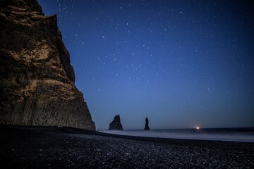 Stars and ship on horizon Reynisfjara black sand beach Iceland