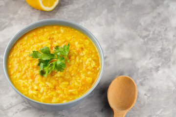 Red lentil soup on a gray background. Bowl of lentil soup on concrete. Traditional middle eastern food