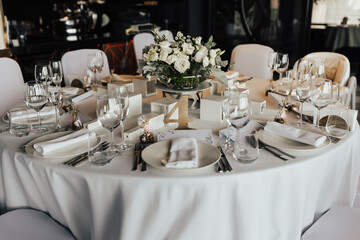 Luxury wedding reception in restaurant. Table decoration white flowers.
