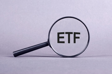 ETF analysis concept. Word through magnifying glass. High quality photo