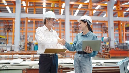 Two engineer manager leader and woman assistant holding laptop and shaking hands for making...