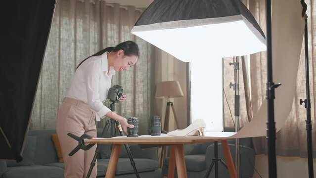 Asian Female Photographer Changing Camera'S Lens While Taking Photos Of Women'S Shoes In Home Studio 
