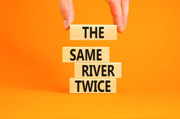 The same river twice symbol. Concept words The same river twice on wooden block. Beautiful orange table orange background. Motivational business the same river twice concept. Copy space.