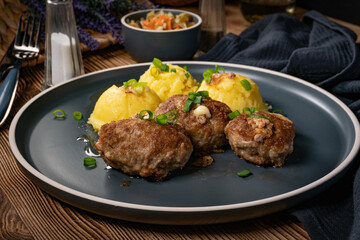 Meatballs with cheese served with boiled potatoes.