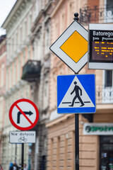 Znaki przejścia dla pieszych i zakazu skrętu w prawo. Tablica odjazdów. Pedestrian crossing and no right turn signs. Departure board. - obrazy, fototapety, plakaty