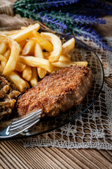 Pork chop in breadcrumbs served with fries and stewed cabbage.