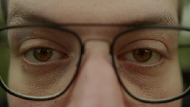 Piercing Gaze of a Young Man with Eyeglasses, Close-Up
