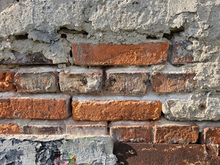 Fragment of an old brick wall with peeling plaster creating abstract patterns, Lodz, Poland.