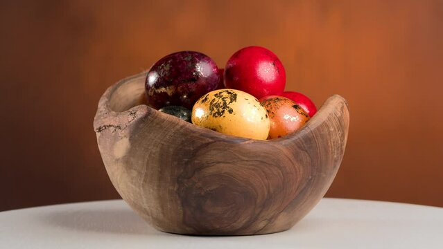 painted and gold leaf decorated Easter eggs in a natural wooden bowl