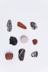 Stones isolated on a white background, Collection of various sea pebble stones on white background. Top view, flat lay, pebble beach isolated on white, Smooth sea rocks, colorful pebbles isolated.