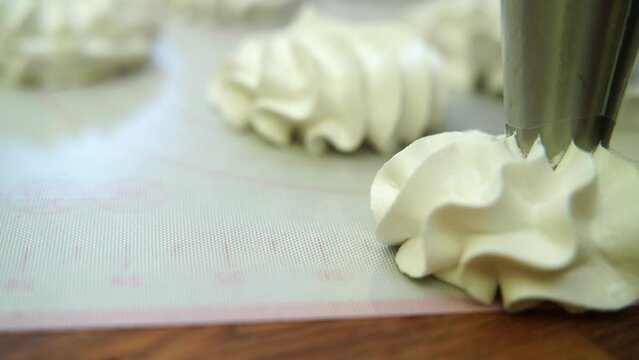 makes marshmallows with a pastry bag. Taken in close-up