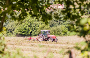 Tractor agricultural machinery equipment harvest a meadow in Asturias. rural farmer occupation