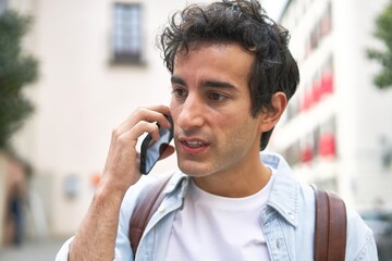 Young man confidently takes on the day, engaging in a productive phone call while en route to work in the city.