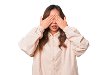 A young chinese woman afraid covering eyes with hands.
