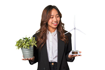 A powerful Chinese businesswoman holds a thriving plant and a windmill model, symbolizing her...