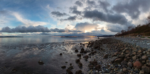 Rocky Beach and White Rock Pier on the West Coast of Pacific Ocean. Dramatic Cloudy Sunset Sky. Vancouver, British Columbia, Canada. Panorama