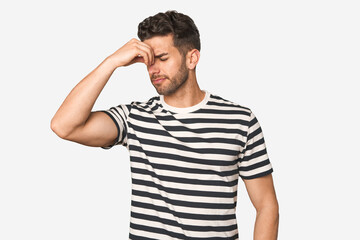 Obraz premium Young handsome man isolated having a head ache, touching front of the face.