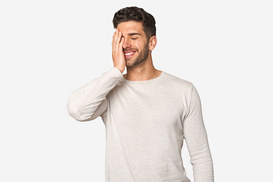 Young handsome man isolated laughing happy, carefree, natural emotion.