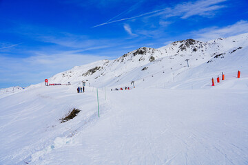Fototapeta na wymiar Snowy ski track in the mountains above Les Ménuires ski resort in the French Alps