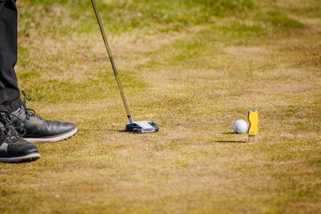 Close-up of golf accessories including a putter, wedge, and ball - obrazy, fototapety, plakaty