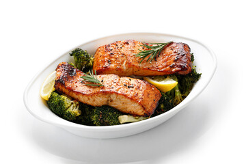 Salmon. Baked, roasted fish steaks, slices. Grilled salmon, trout fillet fish in marinade with broccoli in baking dish isolated on white background. Diet, meal, dinner. 