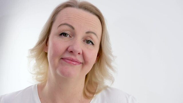 shake head no no shrug blonde woman on white background middle aged dissatisfied with something disappointed at same time smiling tenderly showing well so be it or so it won't be
